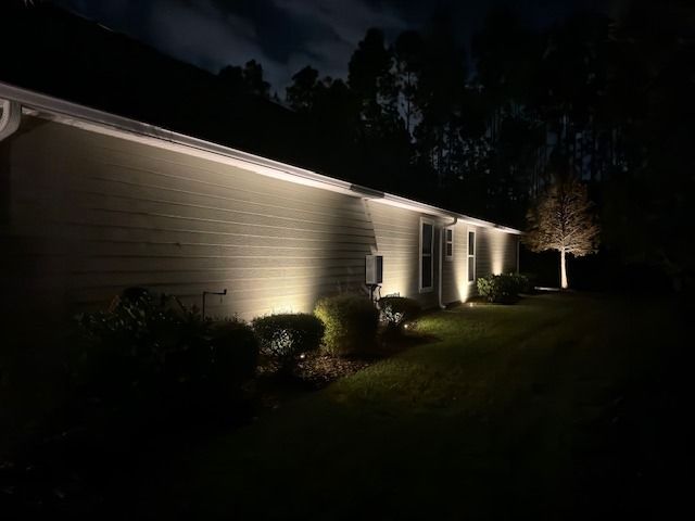 Exterior of house lit with spotlights at night.