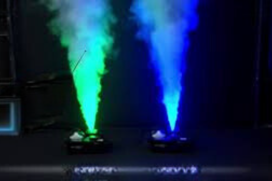 Two cones of smoke are coming out of a machine in a dark room.