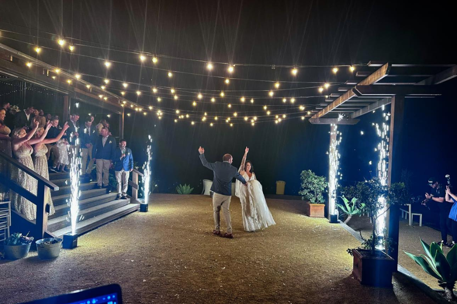 A bride and groom are dancing in front of a crowd at a wedding reception.