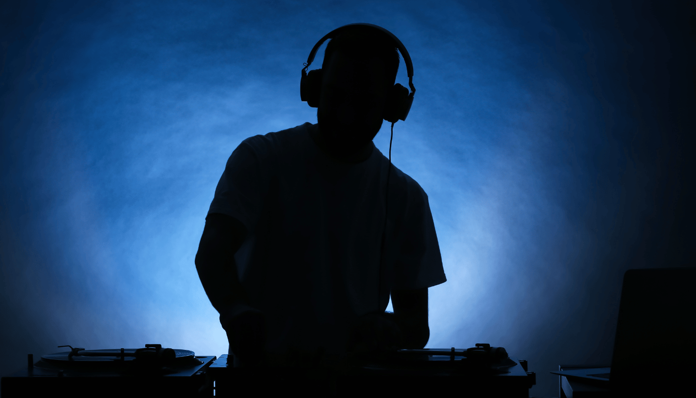 A silhouette of a man wearing headphones playing music.