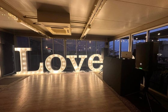 A large love sign is lit up in a room.