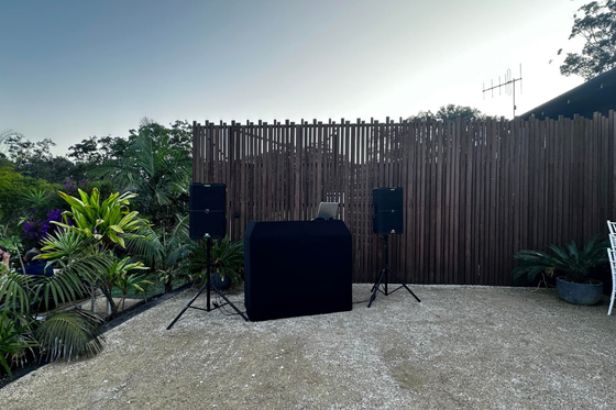 A dj booth is sitting in front of a wooden fence.