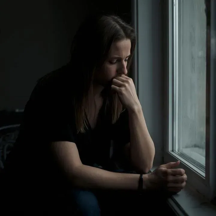 Person sitting quietly with a concerned expression, reflecting on relationship doubts and seeking clarity