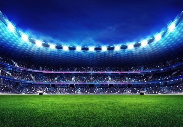 Stadio di calcio illuminato di notte con luci blu e campo verde