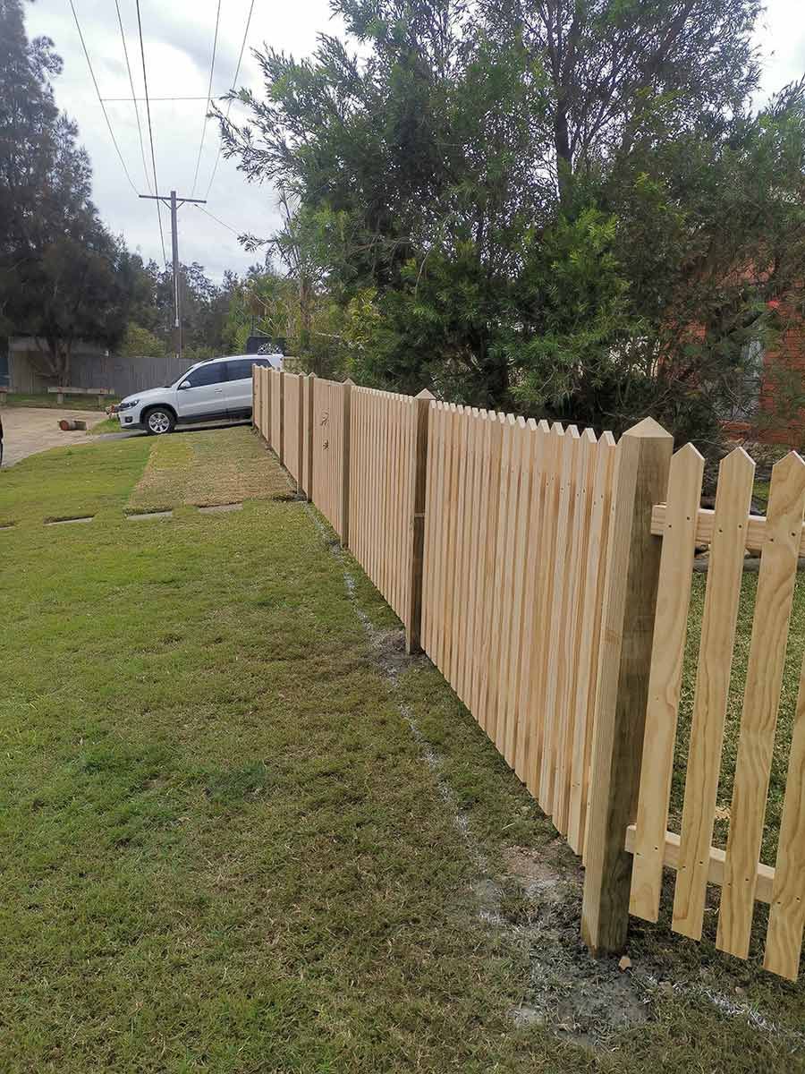 A timber fence is surrounded by white pillars and bushes — WeFence in Lisarow, NSW
