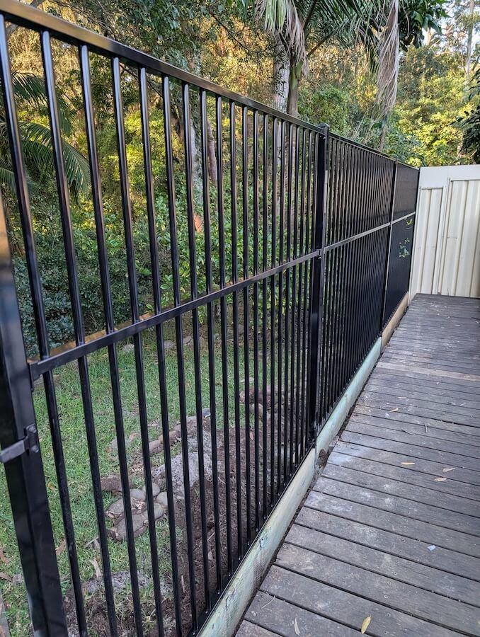A tubular aluminium fence surrounding a wooden deck — WeFence in Lisarow, NSW