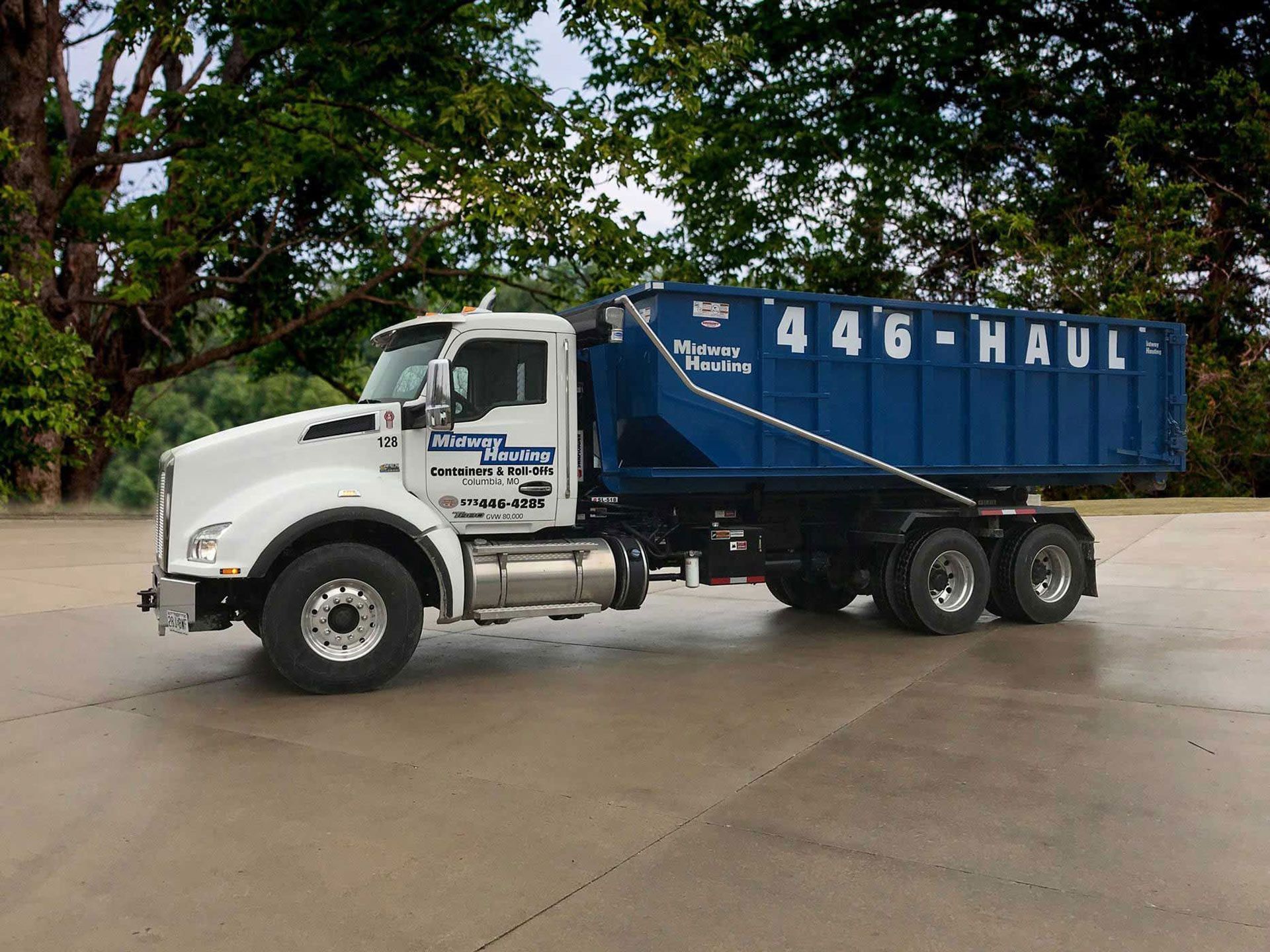 White truck with blue dumpster for 