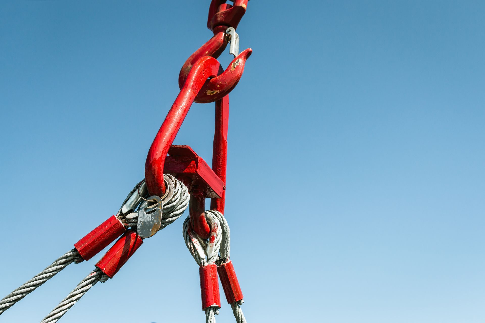 View of a crane hook with a blue sky in the background.