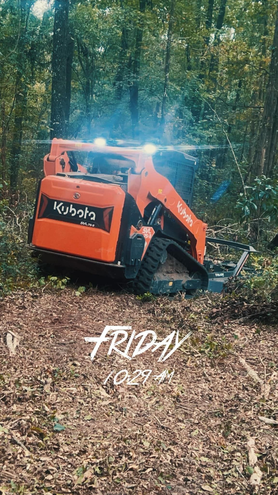 An orange Kubota track loader clears brush in a forest setting, with the text 