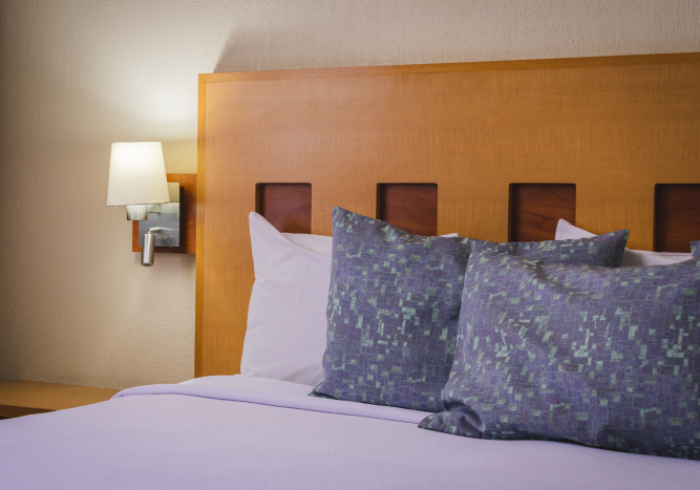 Una cama de hotel con cabecero de madera clara