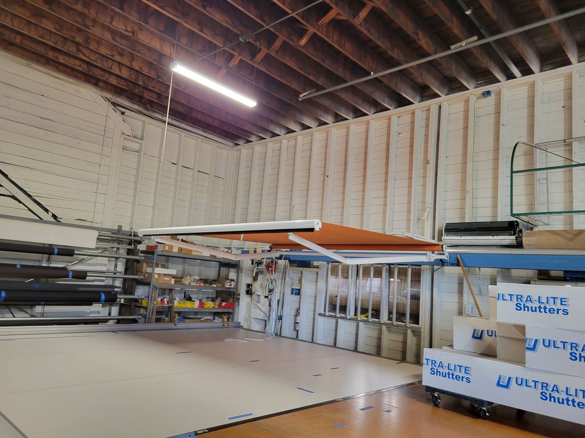 Empty construction workspace with exposed ceiling beams and stacked building materials