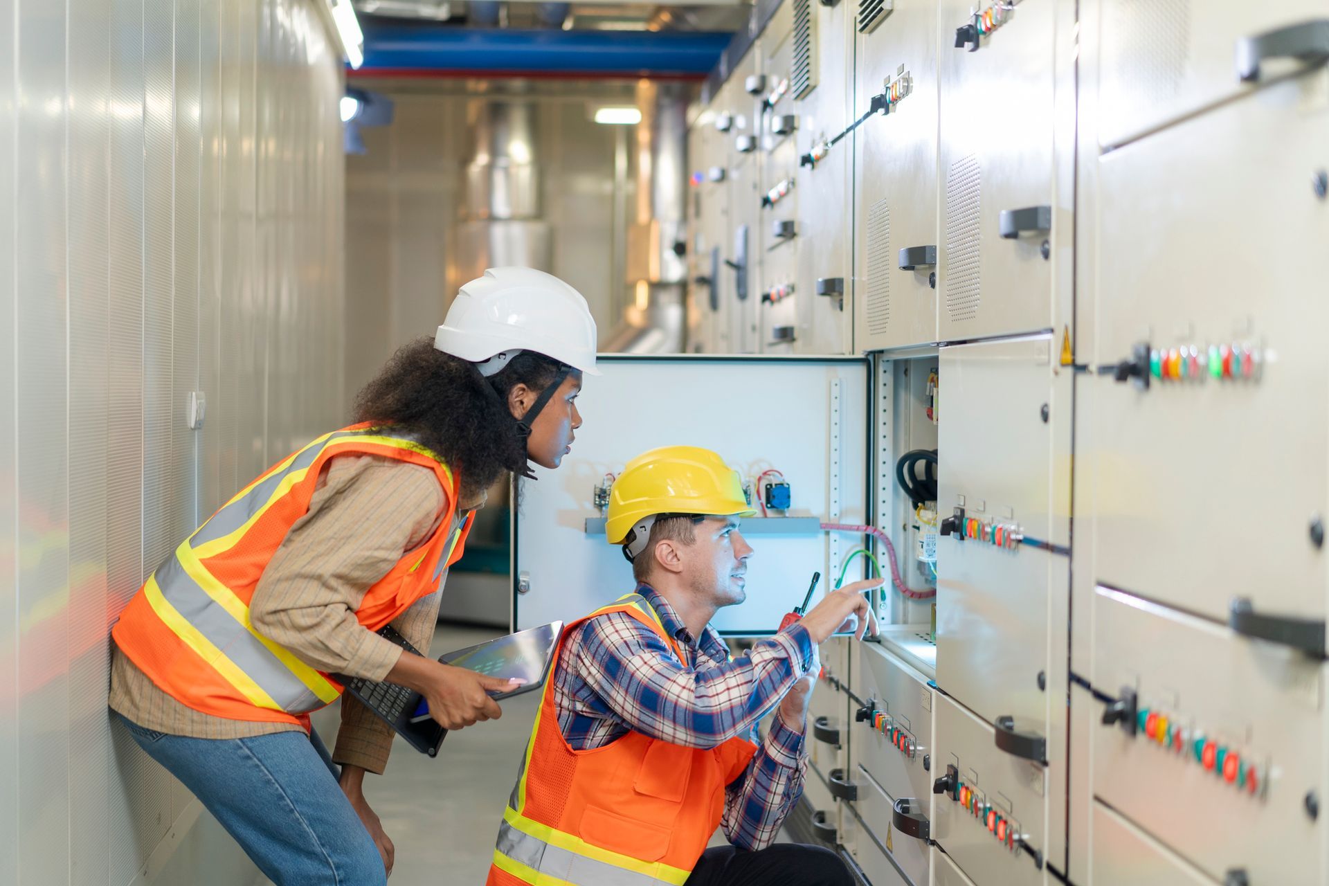 An engineer and a technical worker are verifying the status of an electrical power switchboard. An engineer and a technical worker are verifying the status of an electrical power switchboard.