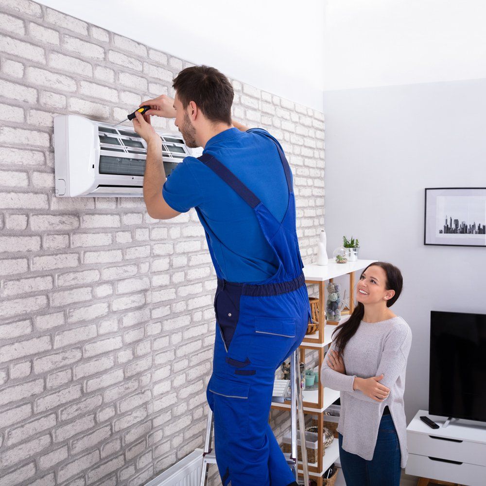 Repair Man Fixing Air Condition — Houston, TX — Environmental Air Systems A professional doing AC repair in Houston, TX
