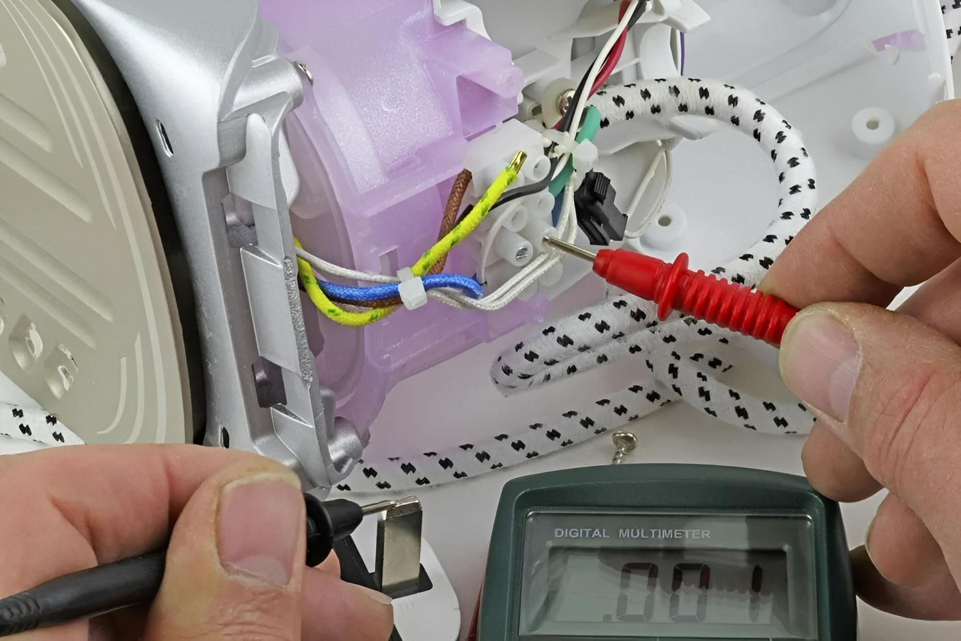 A Person is Using a Multimeter to Check the Voltage of an Iron — Clifford Electrical in Ballina, NSW