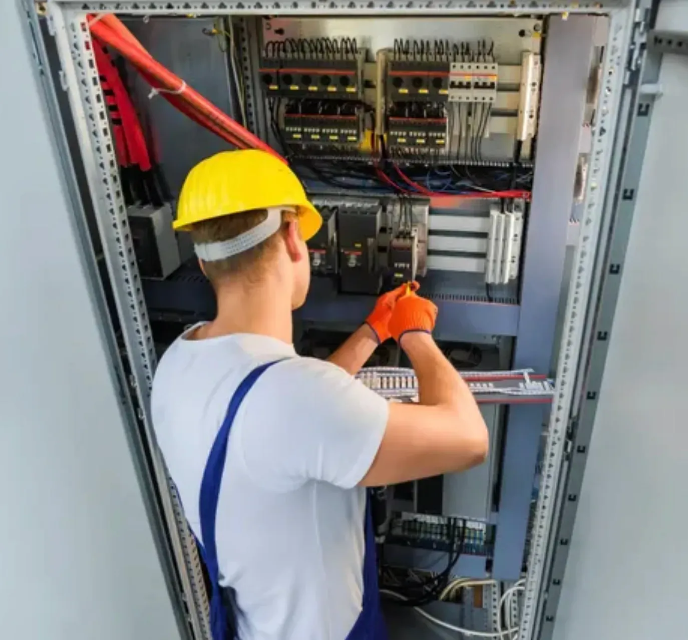 A Person is Using a Screwdriver on an Electrical Board — Clifford Electrical in Ballina, NSW