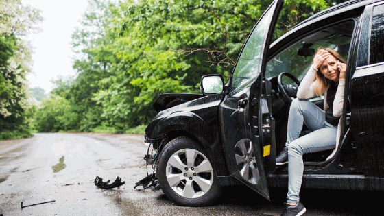 Driver beside a damaged vehicle after an accident
