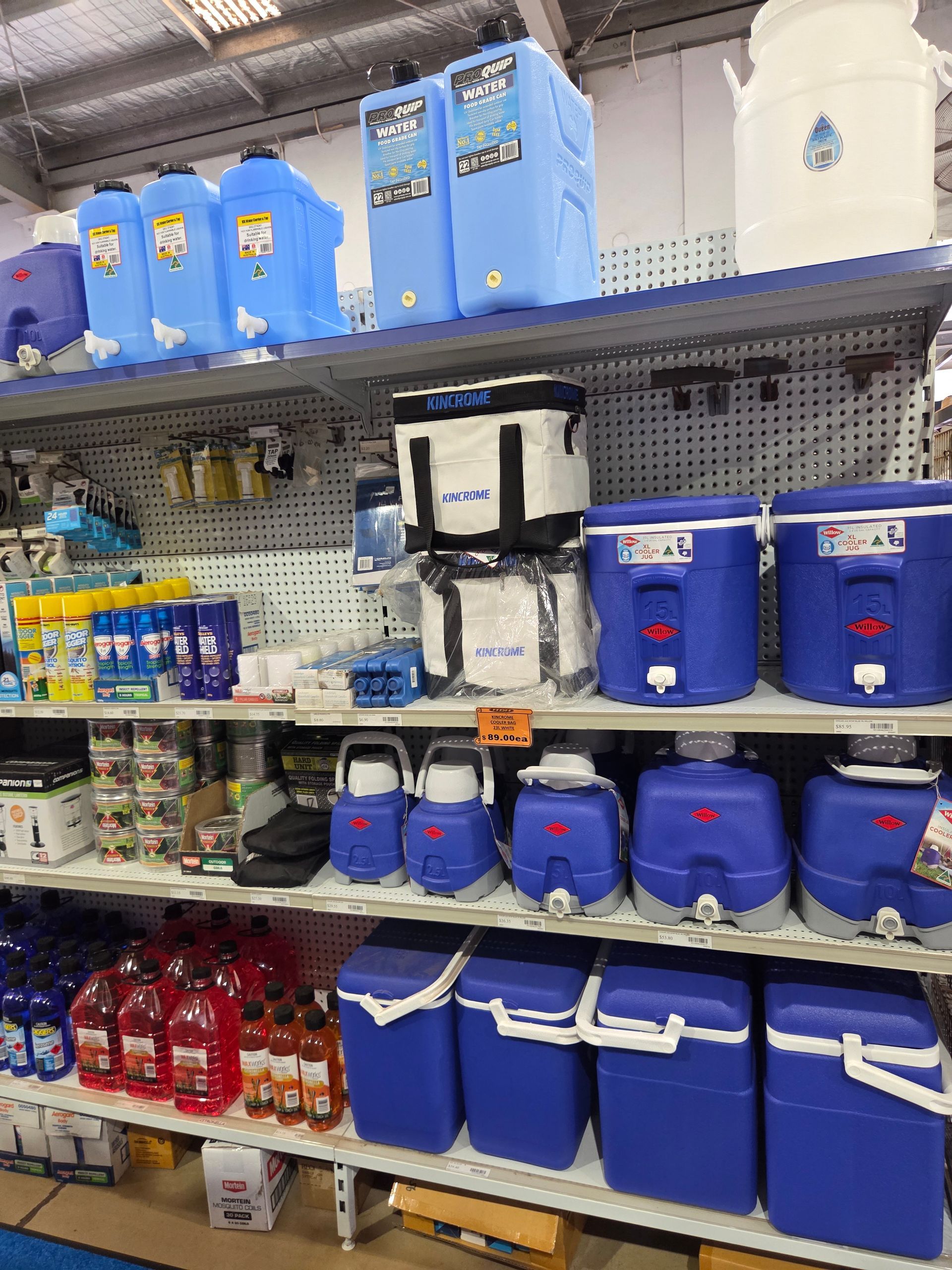 Store shelf stocked with blue coolers, water jugs, and beverage containers in a retail aisle — Humpty Doo Hardware in Humpty Doo, NT