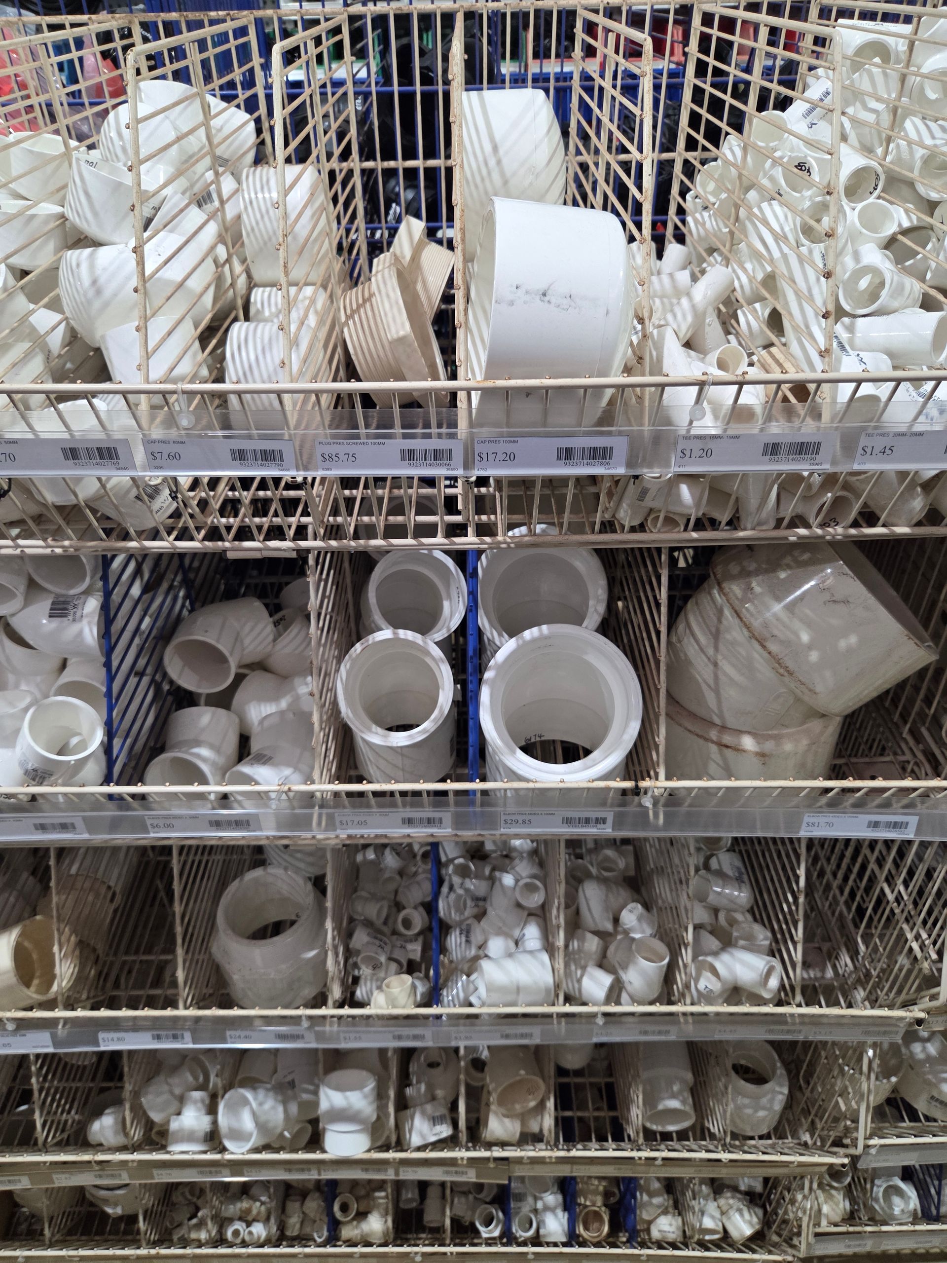 Shelves filled with white ceramic cups, bowls, and mugs in a store aisle — Humpty Doo Hardware in Humpty Doo, NT