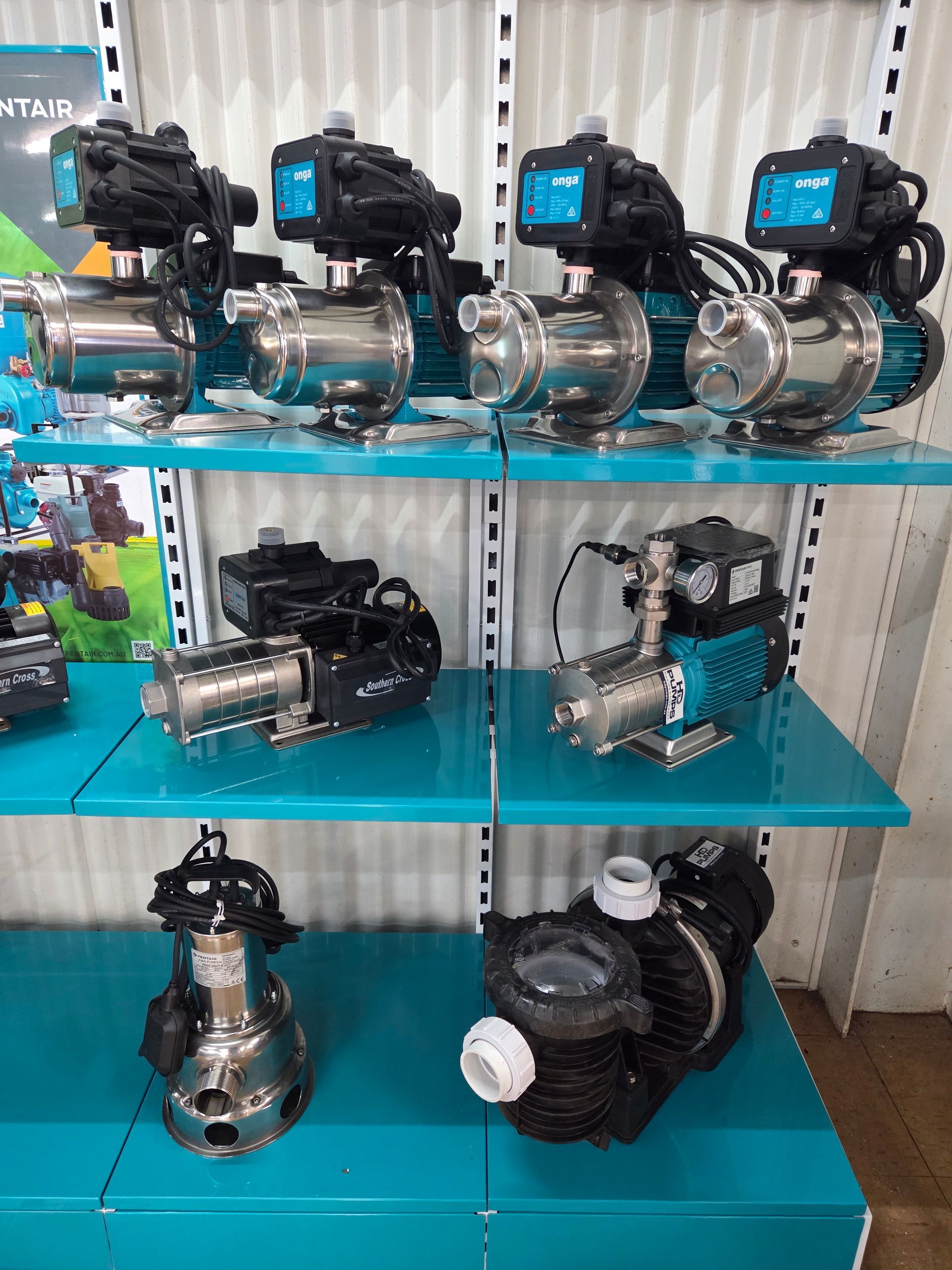 Shelves displaying assorted industrial pumps and motors on a turquoise rack — Humpty Doo Hardware in Humpty Doo, NT