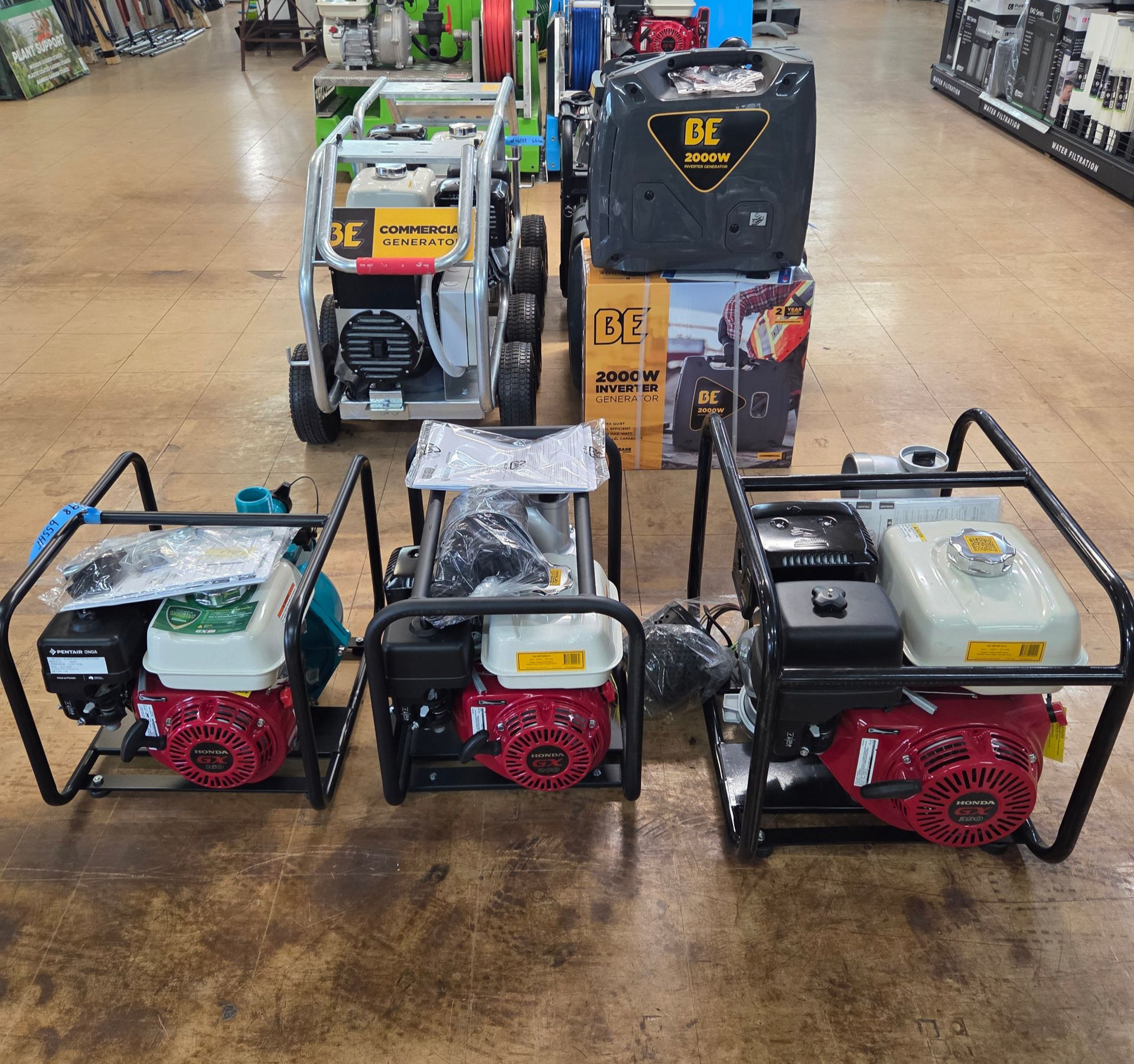 Four portable generators and pressure washers displayed in a store aisle. — Humpty Doo Hardware in Humpty Doo, NT