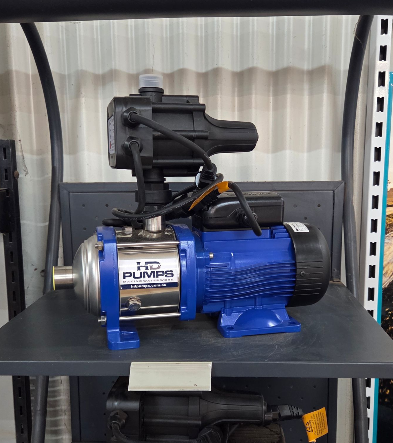 Blue water pump and black motor on a metal shelf in a warehouse-like setting — Humpty Doo Hardware in Humpty Doo, NT