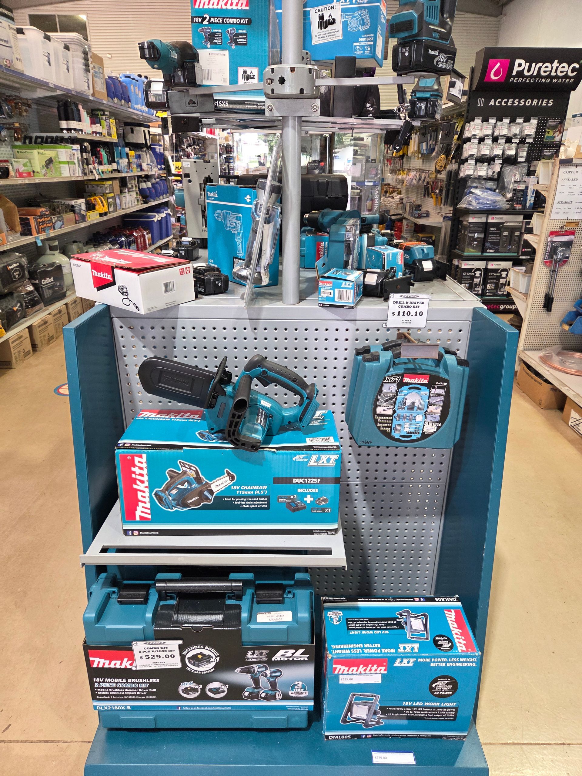 Power tools and accessories displayed on a retail store shelf with blue product boxes and hanging tools — Humpty Doo Hardware in Humpty Doo, NT