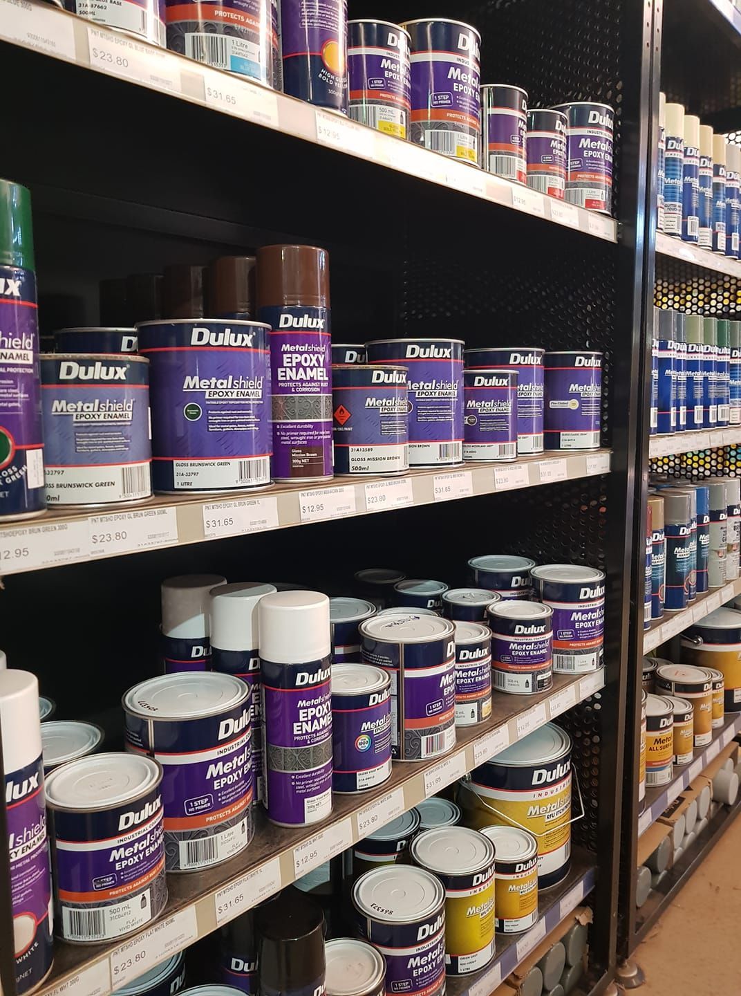 Shelves In a Store Stocked With Rows of Purple Dulux Paint Cans — Humpty Doo Hardware in Humpty Doo, NT