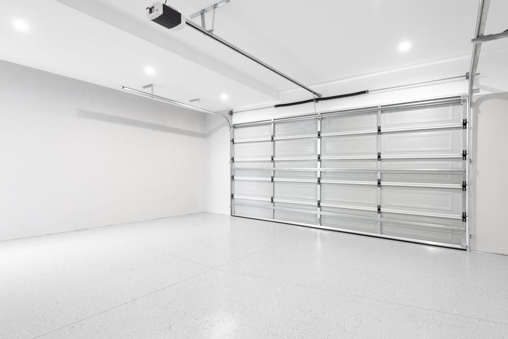 A clean, spacious garage with white walls, a polished floor, and a large, closed overhead metal door.