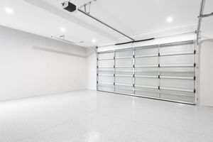A clean, spacious garage with white walls, a polished floor, and a large, closed overhead metal door.