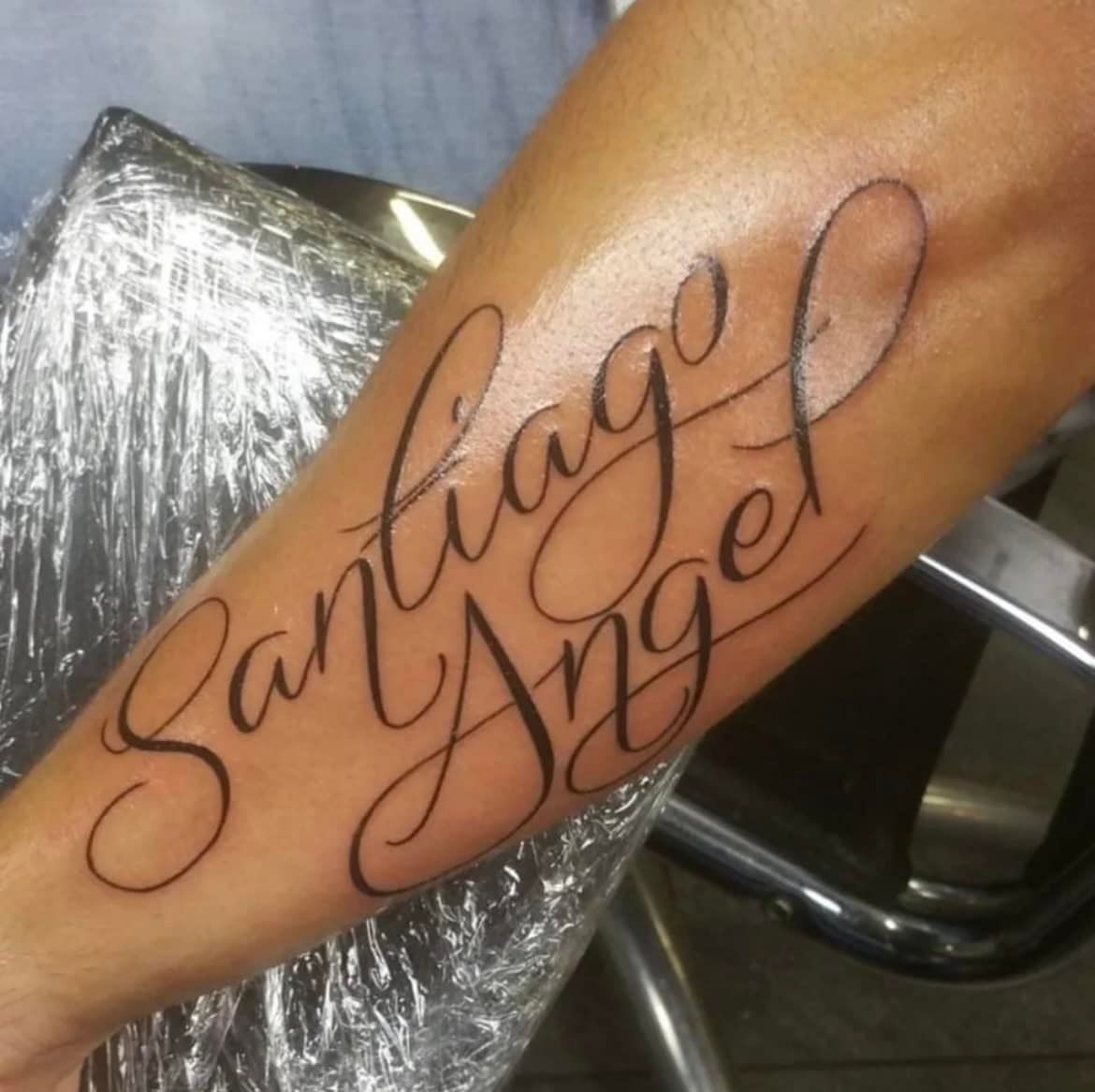 Een verse, sierlijke tatoeage op iemands onderarm met de tekst