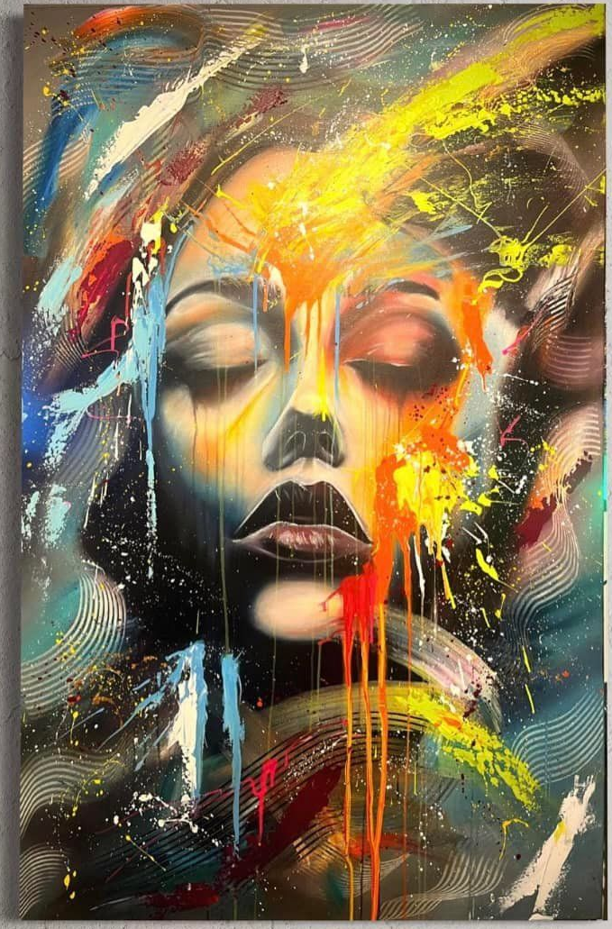 Een levendig, abstract portret met druipende verf in geel, rood en blauw, tentoongesteld in een moderne kamer boven een bank.