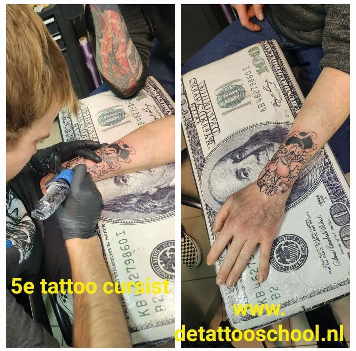 Een tatoeëerder gebruikt een tatoeëermachine op de onderarm van een persoon, waarop een grote afdruk van een biljet van 100 dollar rust.