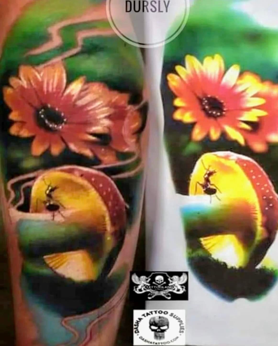 Een levendige tatoeage toont twee oranje bloemen boven een gloeiende gele paddenstoel met een mier die over de hoed kruipt.