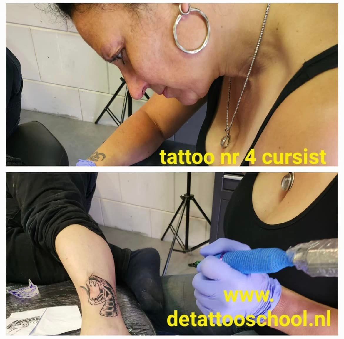 Een persoon in een zwart hemdje en paarse handschoenen tatoeëert de arm van een klant in een tattooschool.