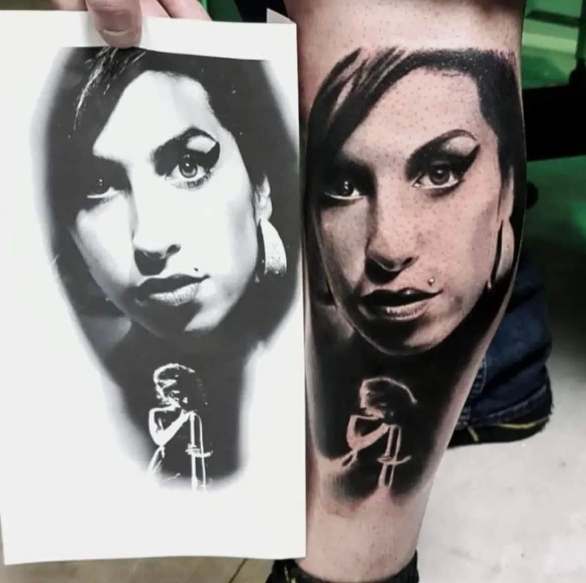Een persoon houdt een voorbeeldafdruk vast naast een voltooide portrettattoo van Amy Winehouse op haar onderbeen.