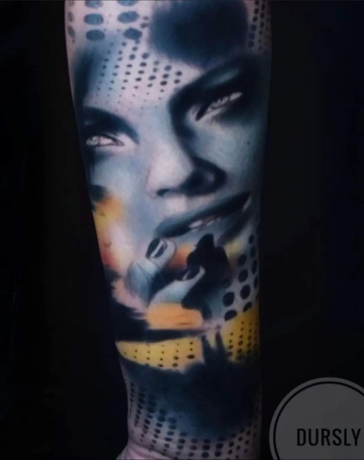 Een tatoeage van een gezicht, gecombineerd met abstracte stippenpatronen, donkere schaduwen en levendige gele accenten.
