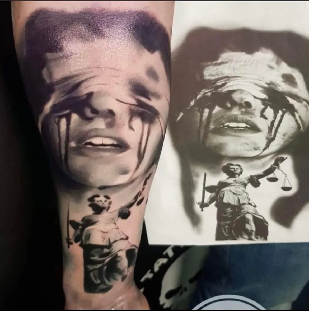 Tattoo op een arm met een huilend, geblinddoekt gezicht boven een afbeelding van Vrouwe Justitia die een zwaard en een weegschaal vasthoudt.