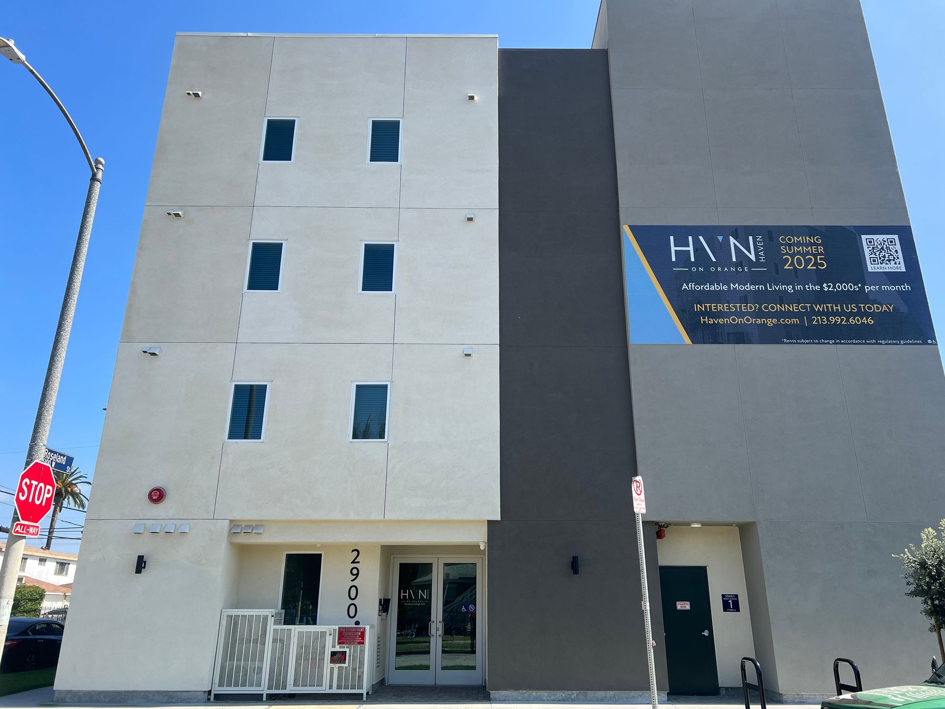 A multi-story beige and dark gray building with a signage banner labeled