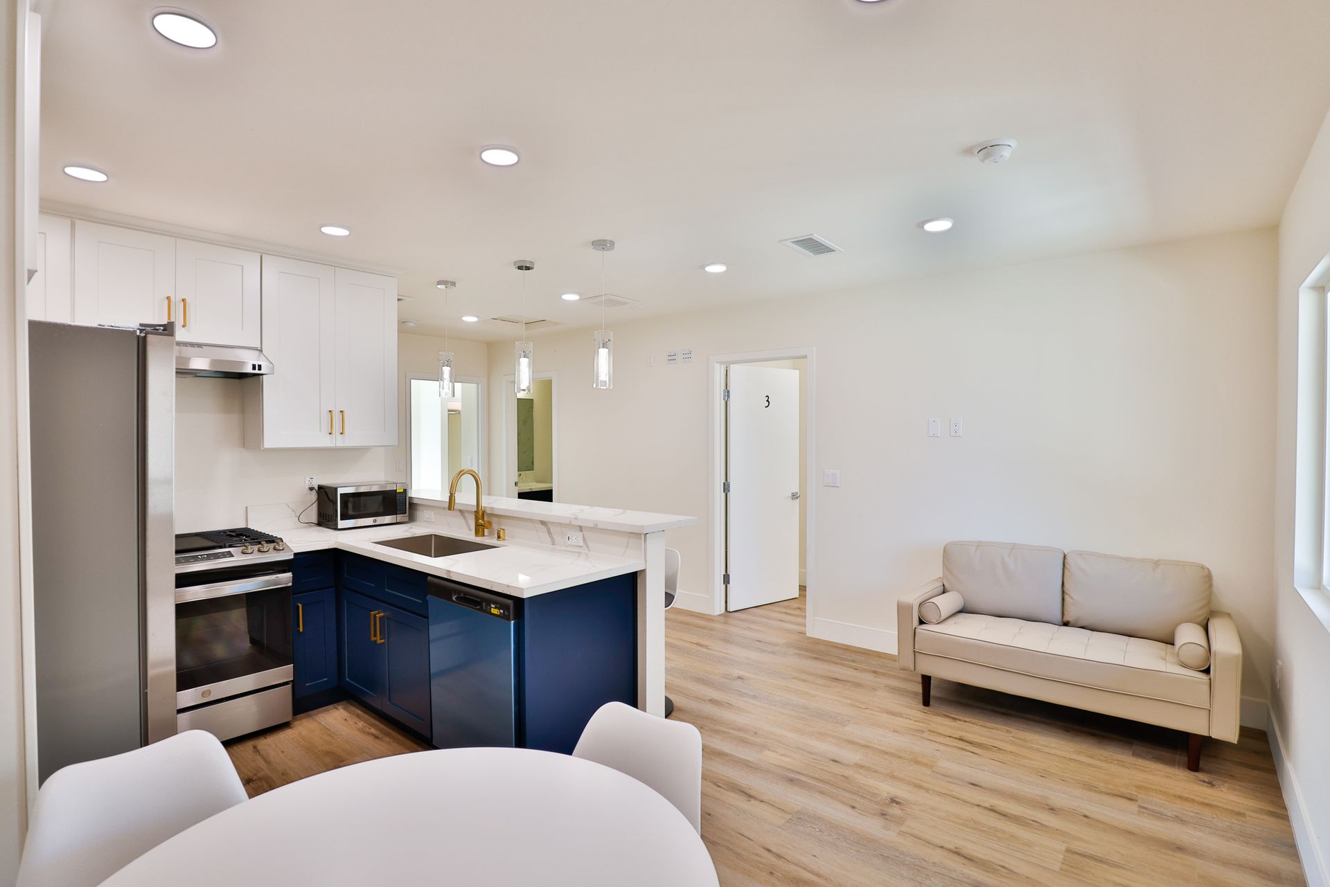 This image shows the Atach kitchen and living room with white furniture.