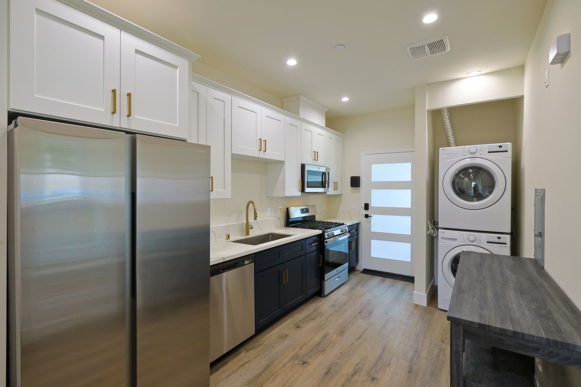 This image showing a beautiful kitchen with laundry set up in it.