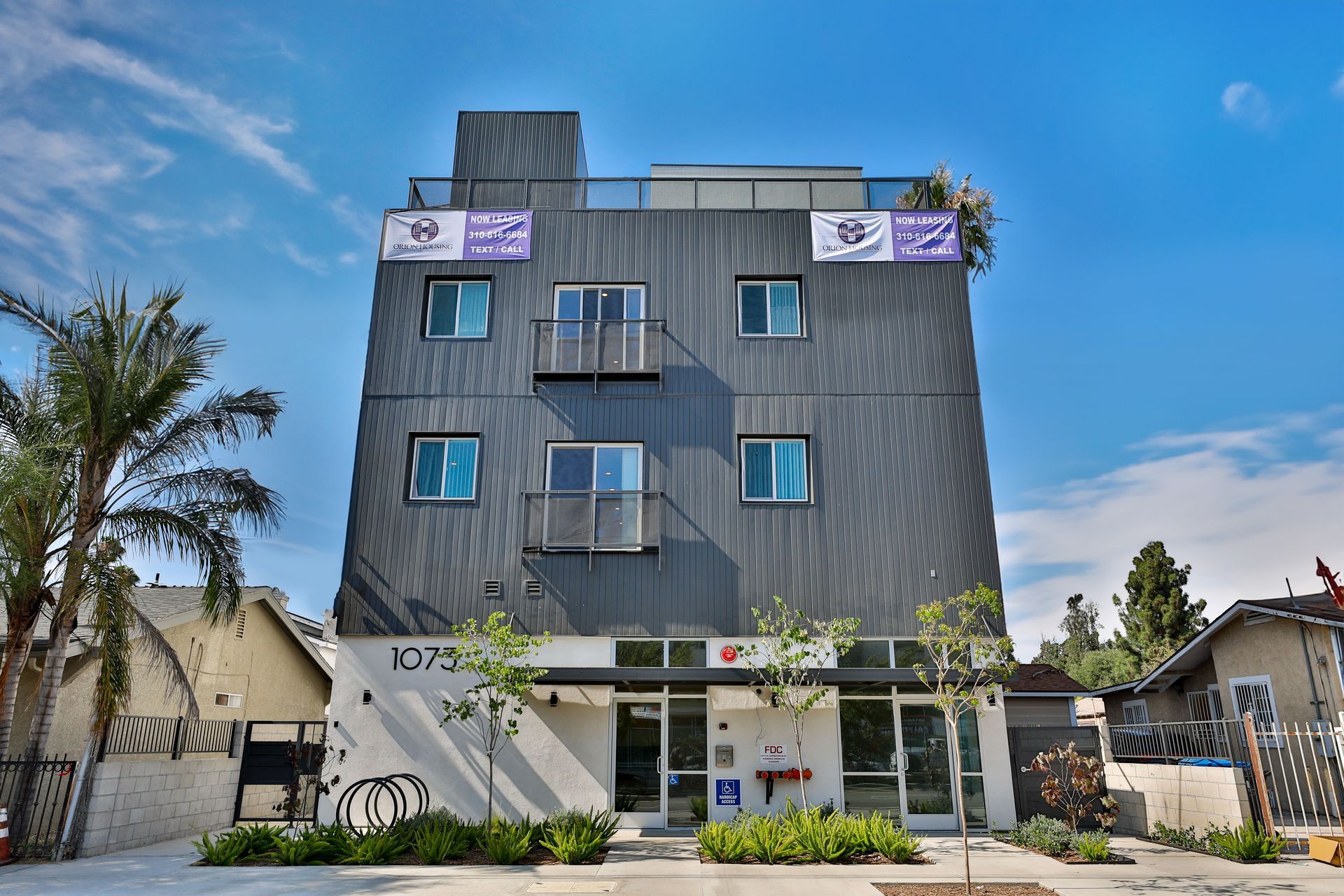 This imge showing a double story building in grey color in a society.
