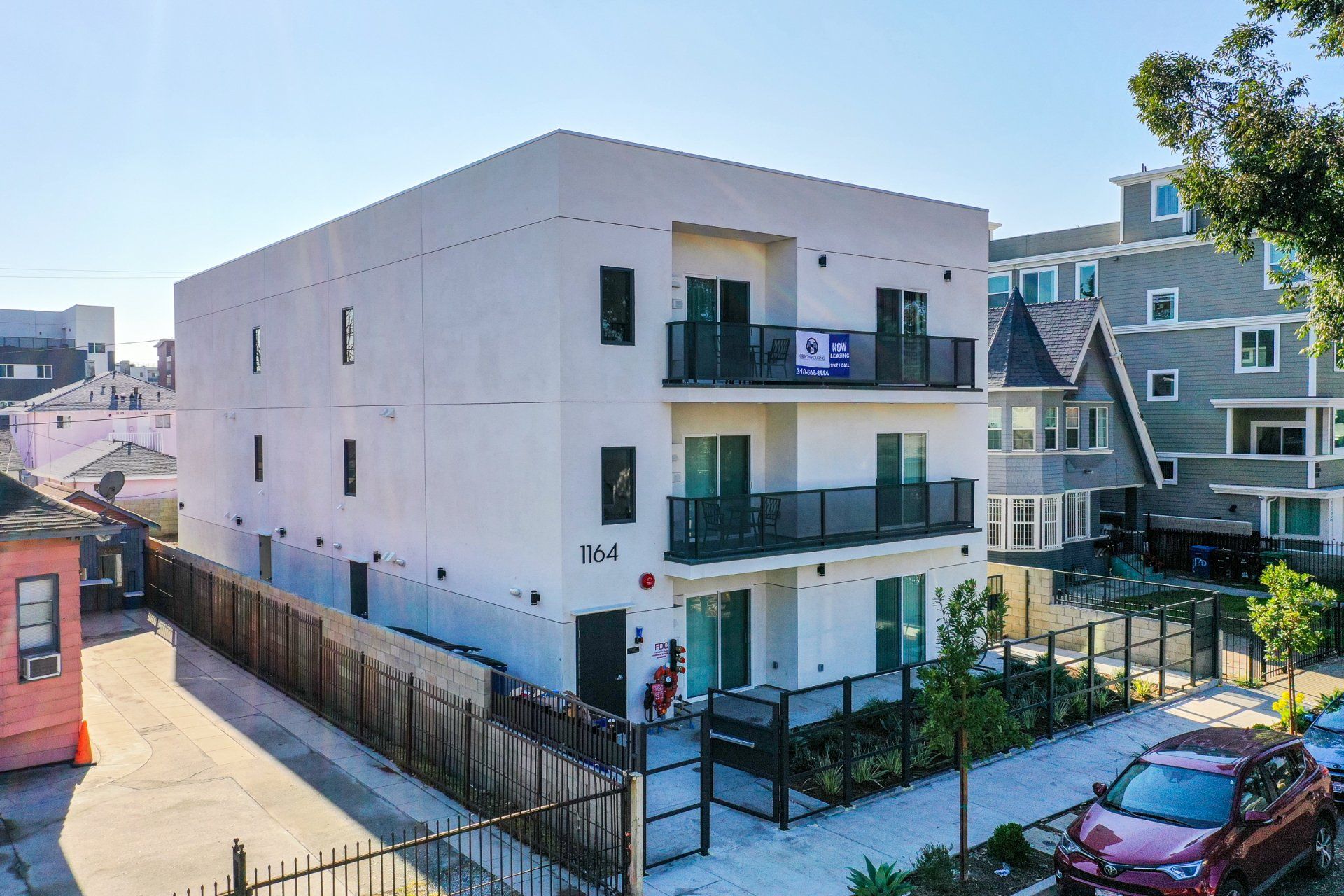 This image shows two buildings on society and cars parked on the side