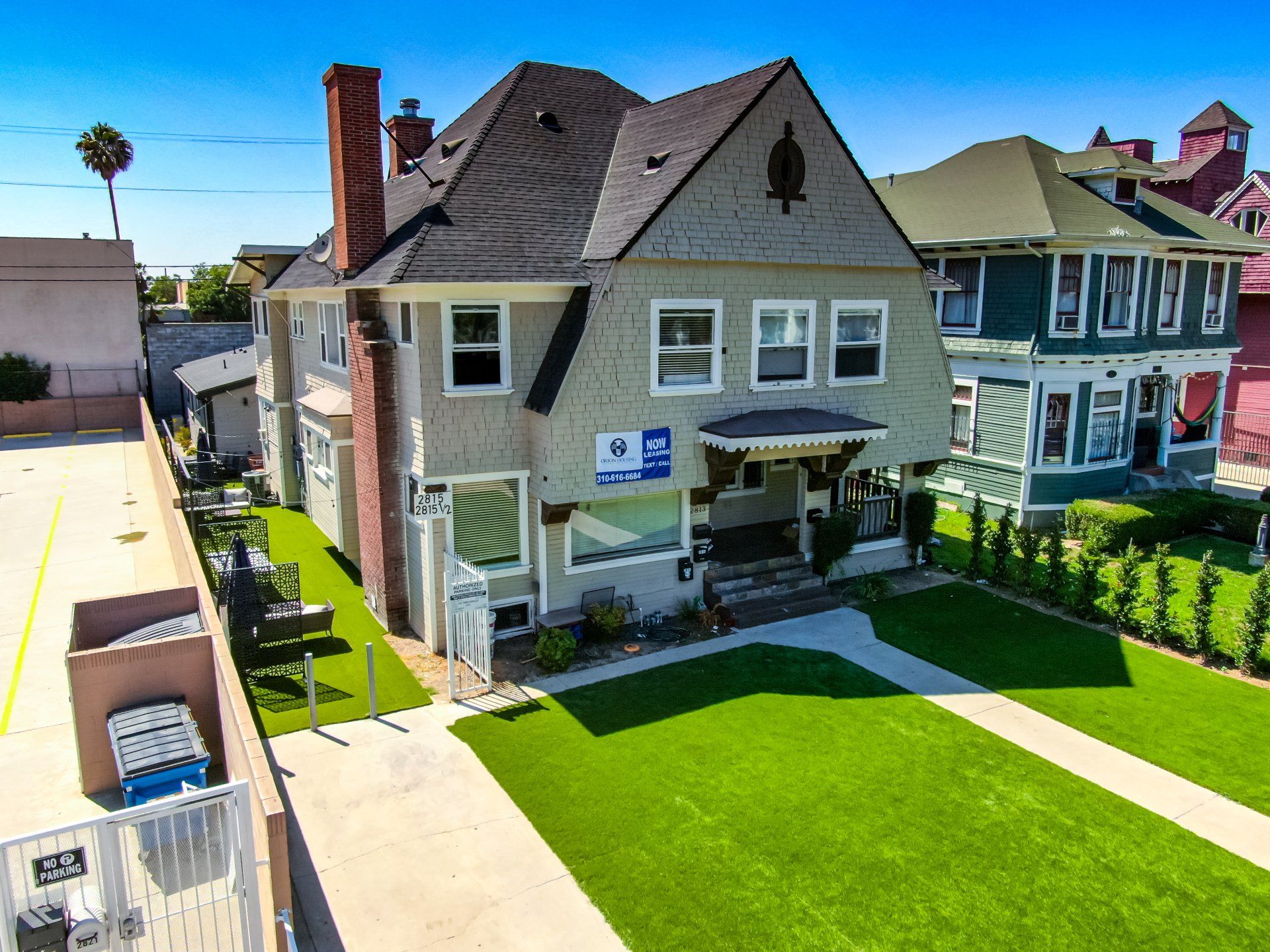 This image shows two houses with a lawn and a sidewalk in the society.