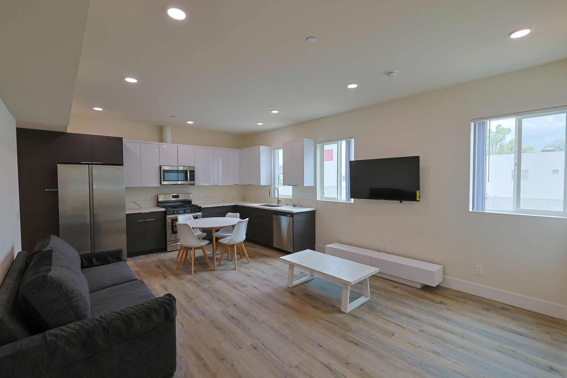 This image shows a small kitchen with some sofa, chair and table.