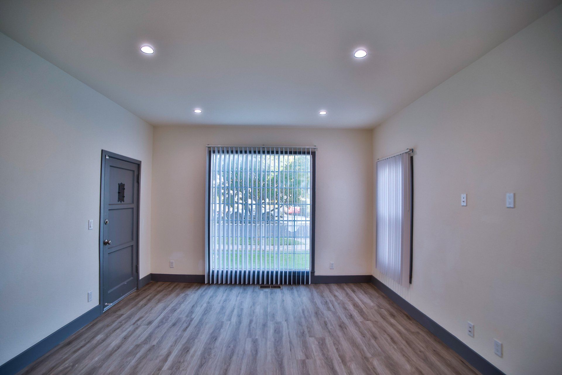 This image showing a spacioous room with one door and window in it.