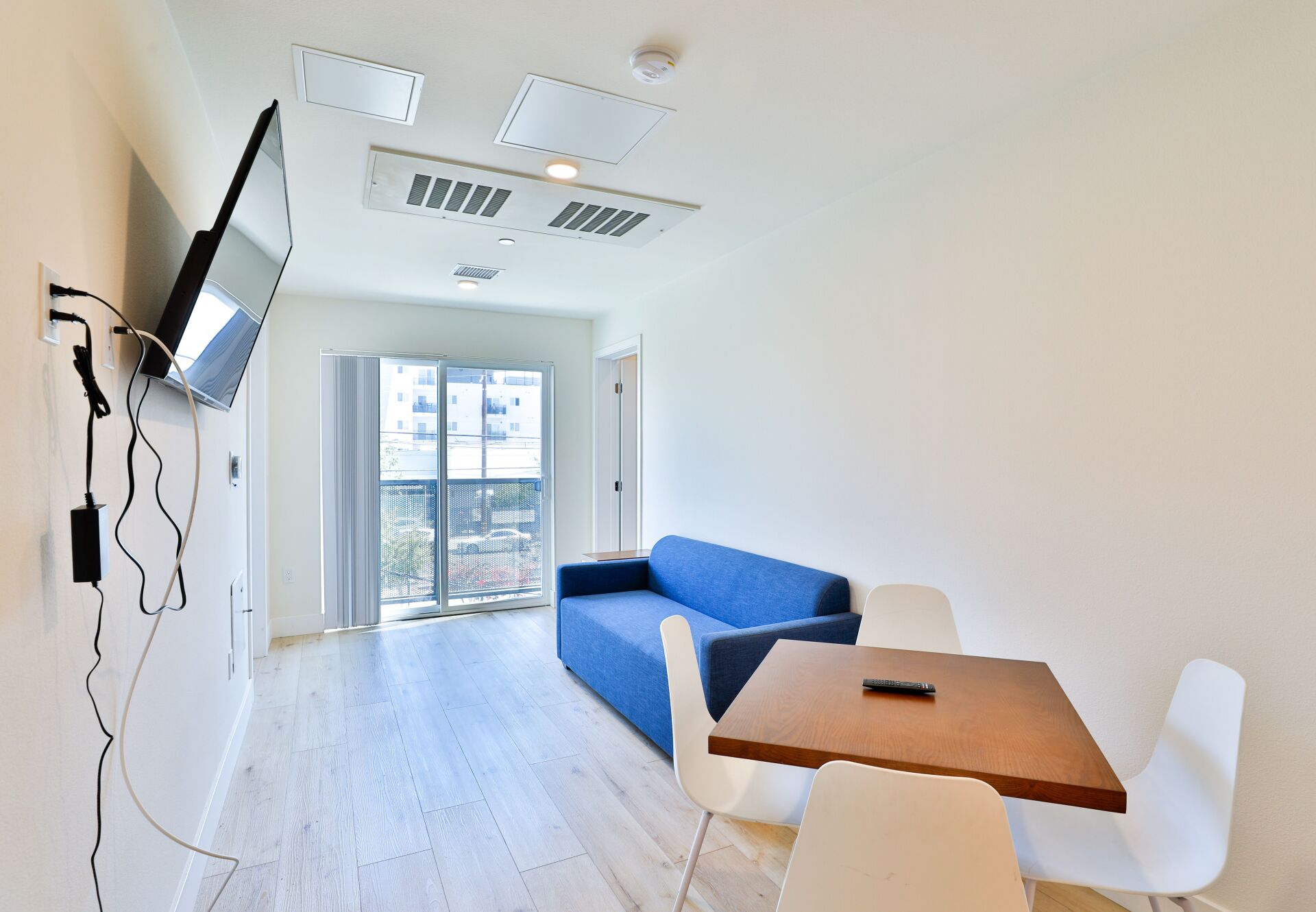 This image shows a sitting in house with LED and sofa.