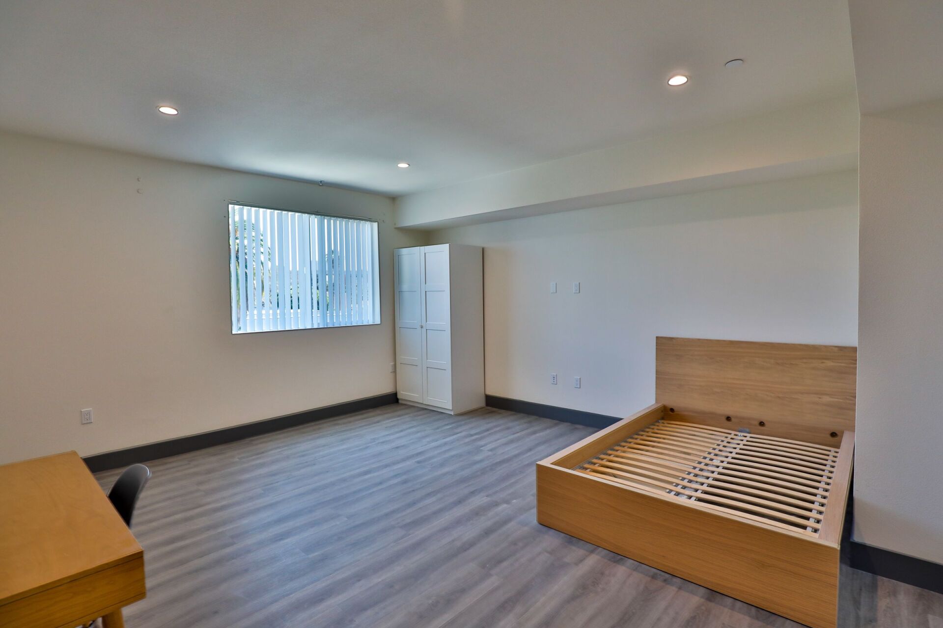 this image shows the brown colored wooden bed in the the white theme room