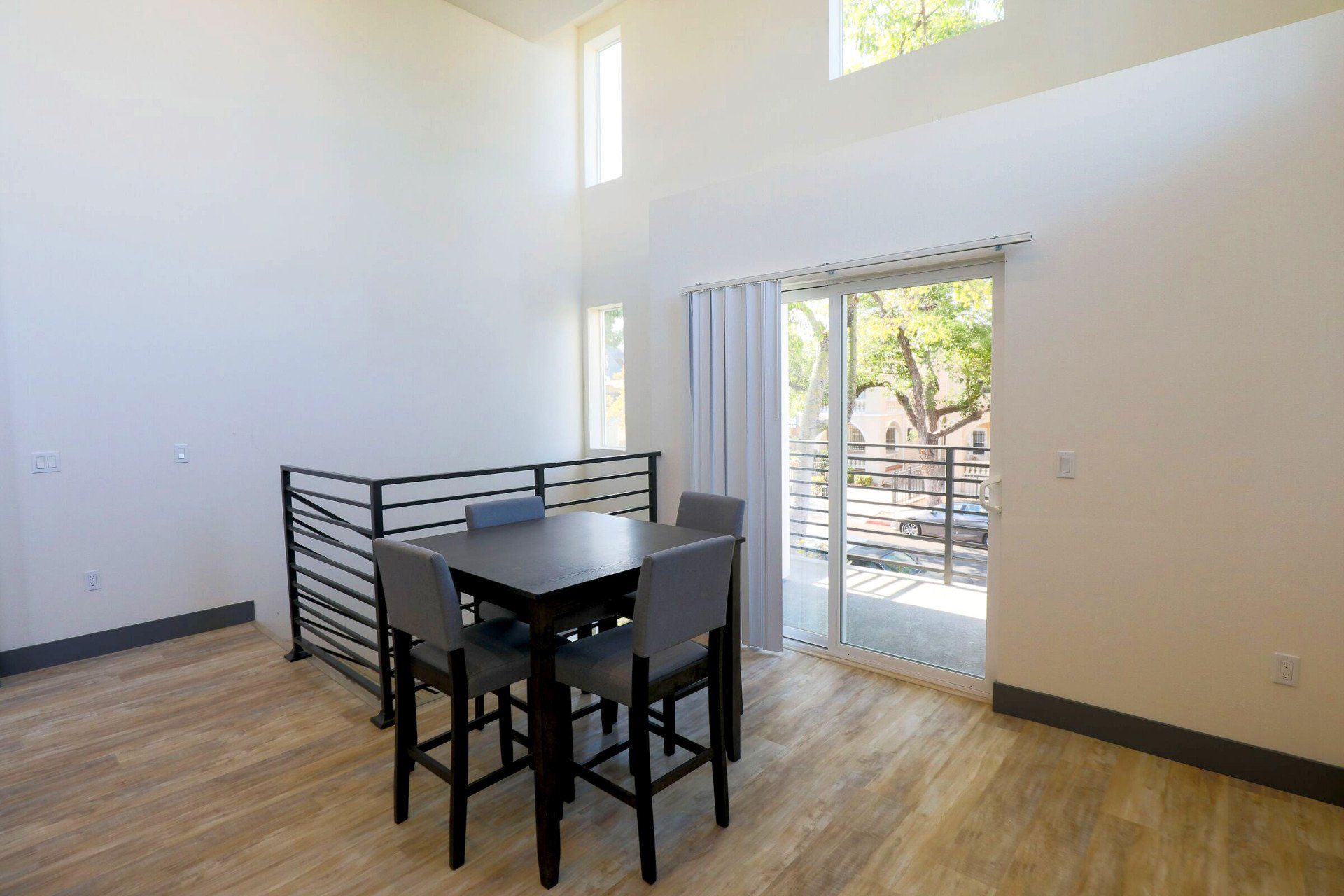 This image showing a 4 table chair in a spacious hall with one window in it.