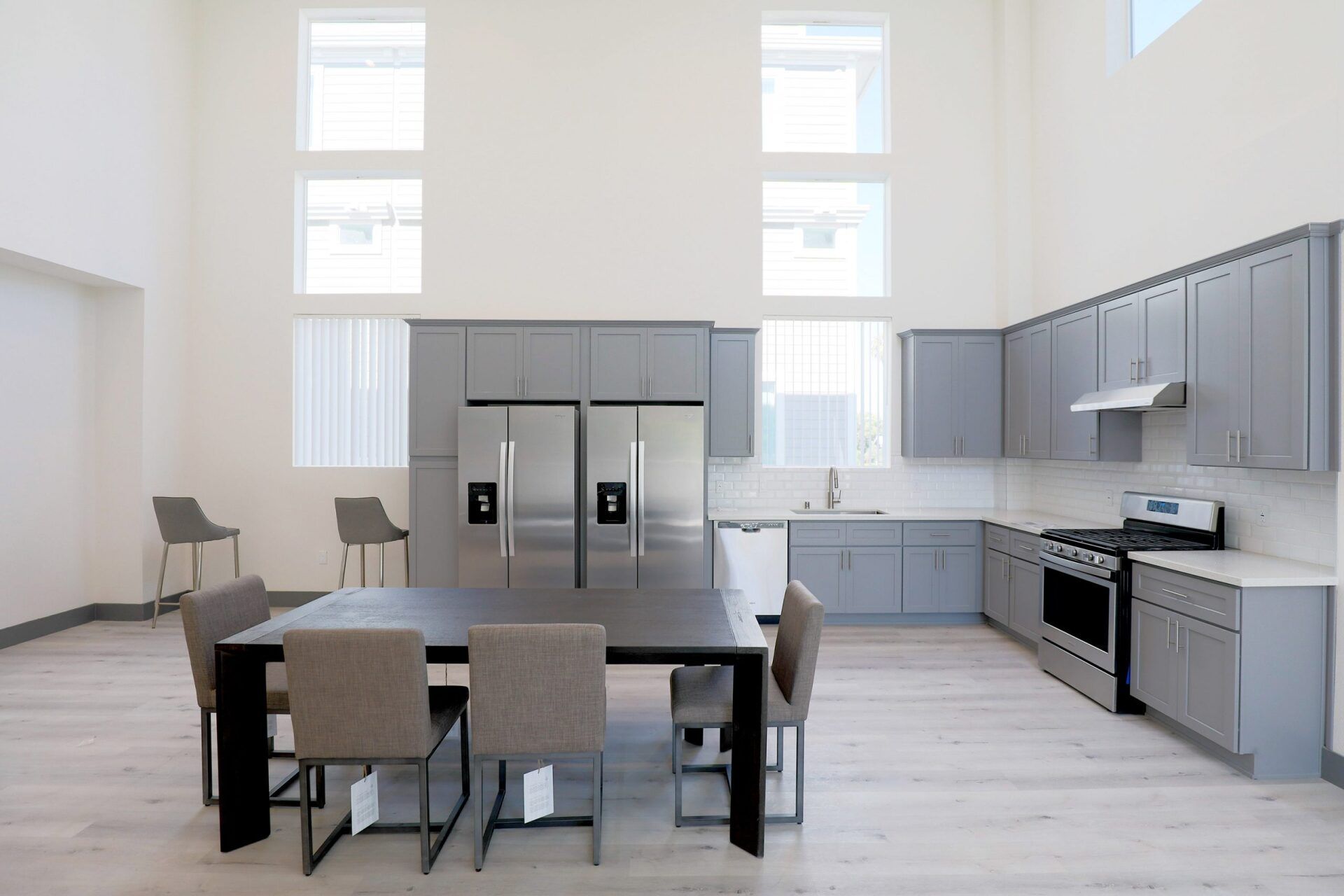 this image shows a kitchen with small dinning table with grey and white background