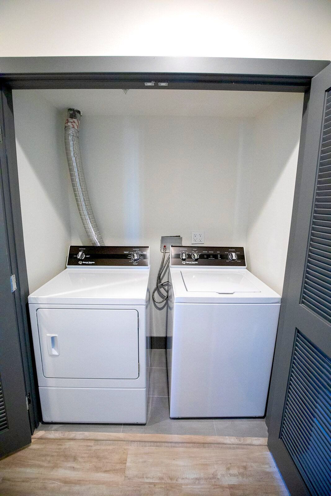 This image showing a laundry room with two washing machines in it.